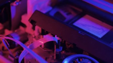 Retro Video Teybi Eklendi ve ÇıkarıIdı - Renkli neon ışıklandırmalı bir video kaseti oynatan, çıkaran ve yeniden yerleştiren bir videonun kusursuz döngüsü.