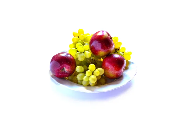 Trauben mit Äpfeln auf dem Teller isoliert auf weißem Hintergrund — Stockfoto