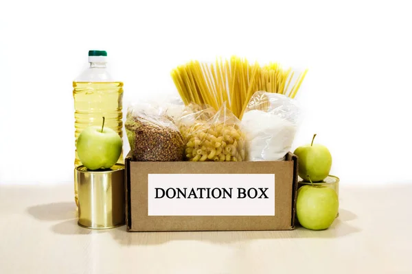 Full donation food box with many products on the white background. Charity concept.