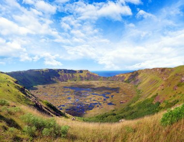 Paskalya Adası 'ndaki Rano Kau yanardağının panoramik görüntüsü - Rapa Nui - beyaz bulutlarla kaplı mavi gökyüzüne karşı.