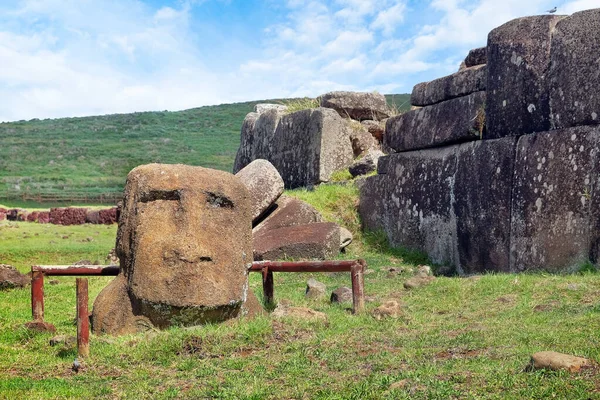 Cabeza Moai y estructura de piedra en el centro ceremonial de Vinapu, en la isla Easer - Rapa Nui, contra un cielo azul cubierto de nubes blancas. — Foto de Stock