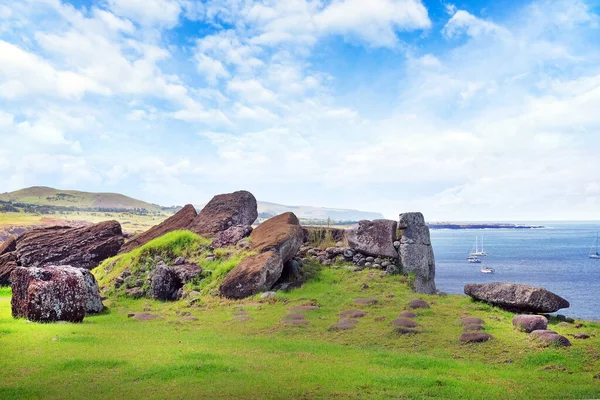 Caduto Moai al centro cerimoniale di Vinapu, sull'isola di Easer, contro l'oceano e un cielo blu coperto da nuvole bianche. — Foto Stock