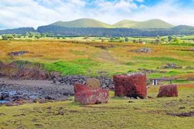 Vaihu 'nun merasim merkezinde düşmüş Moai, Easer Adası' nda, beyaz bulutlarla kaplı mavi gökyüzüne karşı.
