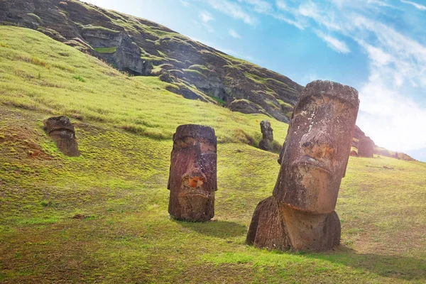 Moai on the slopes of the Rano Raraku Volcano, on Easer Island, against a blue sky covered by white clouds. — Stock Photo, Image