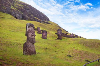 Rano Raraku Volkanı 'nın yamaçlarında, Easer Adası' nda, beyaz bulutlarla kaplı mavi gökyüzüne karşı..