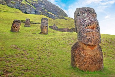 Rano Raraku Volkanı 'nın yamaçlarında, Easer Adası' nda, beyaz bulutlarla kaplı mavi gökyüzüne karşı..