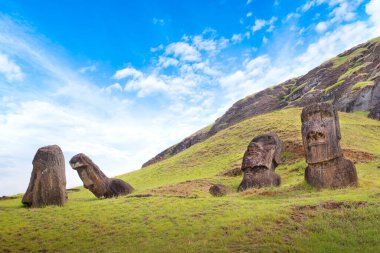 Rano Raraku Volkanı 'nın yamaçlarında, Easer Adası' nda, beyaz bulutlarla kaplı mavi gökyüzüne karşı..