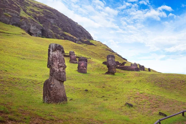 Rano Raraku Volkanı 'nın yamaçlarında, Easer Adası' nda, beyaz bulutlarla kaplı mavi gökyüzüne karşı..