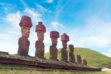 Paskalya Adası 'ndaki Anakena sahilindeki Ahu Nao-Nao merasim merkezinde, mavi gökyüzüne karşı taş yapı ve Moai heykelleri..