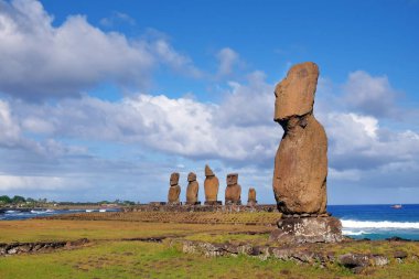 Paskalya Adası 'ndaki Ahu Tahai törensel kompleksindeki Moai heykelleri beyaz bulutlarla kaplı mavi gökyüzüne karşı..