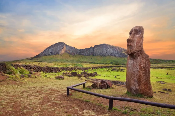 Paskalya Adası 'ndaki Ahu Tongariki merasim merkezinin girişindeki taş çit ve Moai heykelleri Rano Raraku volkanı kraterine karşı renkli bir günbatımı gökyüzü ile kaplıydı..