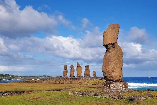 Paskalya Adası 'ndaki Ahu Tahai törensel kompleksindeki Moai heykelleri beyaz bulutlarla kaplı mavi gökyüzüne karşı..