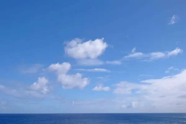 Vue depuis la côte de l'île de Pâques, ciel bleu couvert de nuages blancs, au-dessus de l'océan Pacifique. — Photo