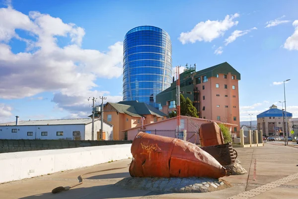 Modern buldings near the shores of Punta Arenas, against the ocean covered by a blue sky.