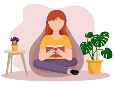 Kız, yumuşak bir puf üzerinde otururken kitap okuyor..