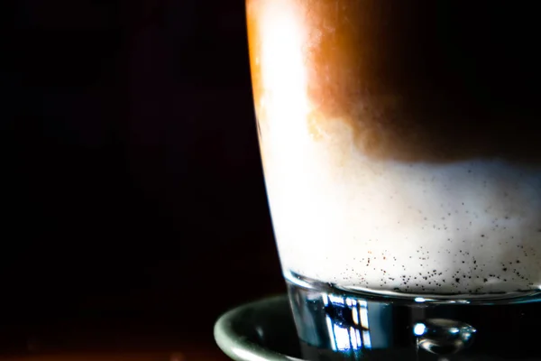 Kapalı katmanlı espresso içeceği, siyah arka plana karşı.