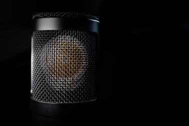 Büyük diyafram yoğunlaştırıcılı mikrofonun izole edilmiş görüntüsü siyah arkaplanda izole edilmiş.