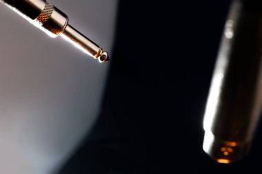 Beyaz Arkaplan Önünde Metal Quarter Inch Connector ve Siyah Arkaplan Önünde XLR Connector ile Mikrofon Kablosunda Sonların Soyut Kapanışı