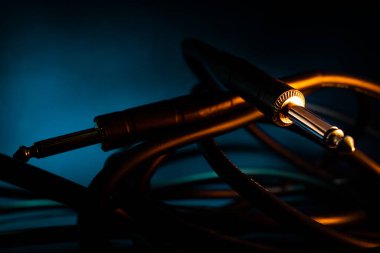 Çeyrek inç Jack Bağlayıcısının Kapanışı Teal Arkaplanındaki Karışık Kabloda Turuncu Işıklandırma ile Yatıyor