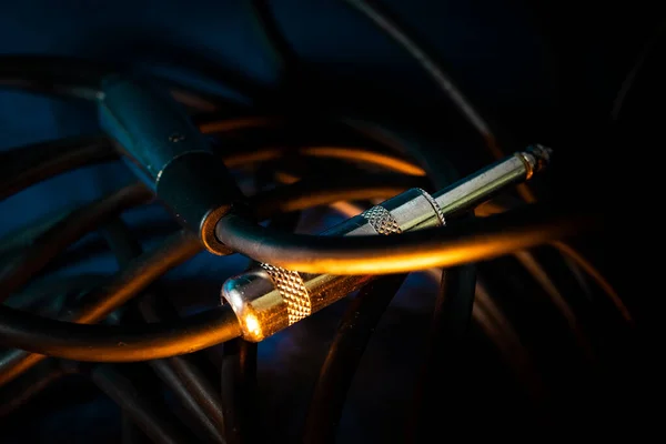 Metal Çeyrek İnç Bağlantının Makro Kapanışı Mikrofon Kablo Bağlantısının sonu Teal Arkaplan 'da Turuncu Işıklandırma ile Cord' da