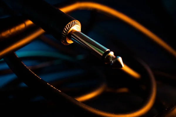 Quarter Jack Connector 'ın Makro Kapanışı Teal Arkaplanındaki Karışık Kordonun Önünde Turuncu Işıklandırma