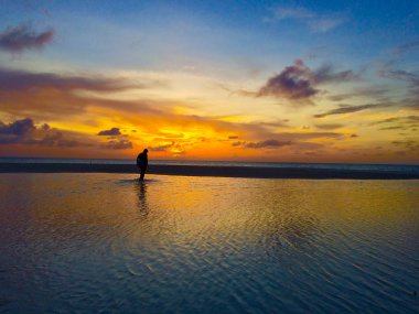 Woman alone in the sea of aruba clipart