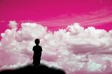 Pembe gökyüzüne siluet arayan yalnız bir çocuk