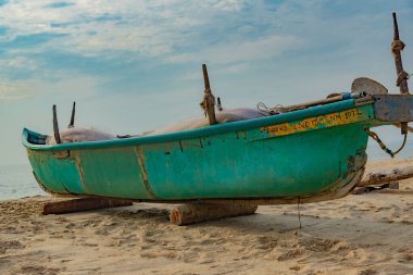 Mavi gökyüzünün altında park etmiş bir balıkçı teknesi.