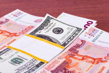 Ahşap arka plan üzerinde para wads: ruble, dolar ve Euro