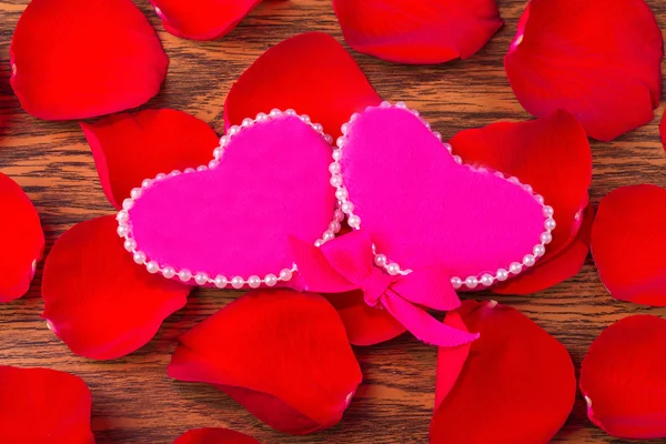 Pojęcie miłości i romansu: dwie różowe serca i płatki r — Zdjęcie stockowe