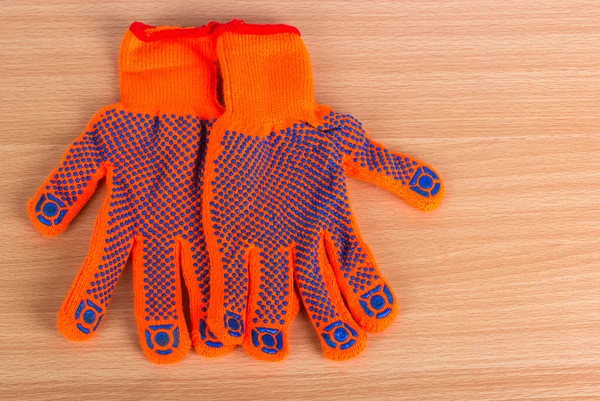 The two gloves lay on a flat wooden surface — Stock Photo, Image