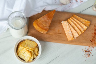 Kırmızı biberli peynir ve tahta tabakta kraker.