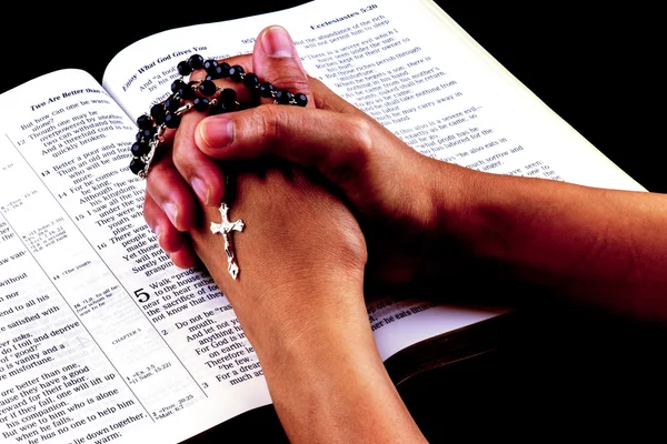 Tespih açık İncil üzerinde elleriyle dua