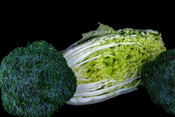 Repolho chinês e brócolis em um fundo preto — Fotografia de Stock