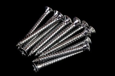 Pile of Wood Screws on a Black Background clipart