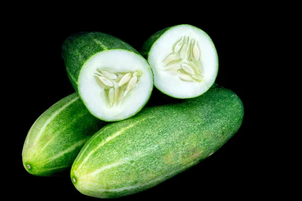 Whole and Cut Organic Cucumbers on a Black Background — Stock Photo, Image