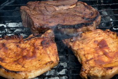 Domuz eti ve biftek ızgarada pişiyor.