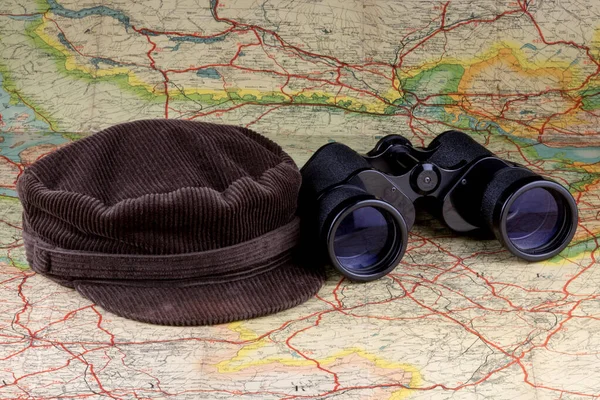 旧路线图上的灯芯绒帽和双筒望远镜 — 图库照片
