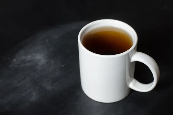 Cup of hot tea on a black board and text — Stock Photo, Image