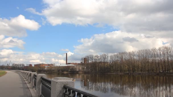 Słoneczny dzień wiosny nad rzeką. Miasto nasyp na przedmieściach Sankt Petersburga. — Wideo stockowe