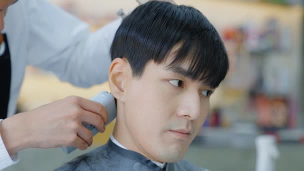床屋は顧客のための耳の区域を切るためにクリッパーを使用している お客様のための髪を設計するためのプロの美容師 美容室 理容室事業コンセプト — ストック動画