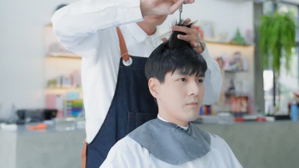 Tukang Cukur Menggunakan Gunting Untuk Memotong Rambut Klien Pria Asia — Stok Video