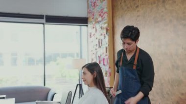 Profesyonel berberler, sık sık boyama yüzünden kırılan uzun saçlı kadın müşterilerinin uçlarını kesmek için makas kullanır..