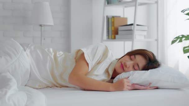 若い美しいアジアの女性がベッドの上に横たわっています ストレス 午前中に彼女のベッドの上をオンにします — ストック動画