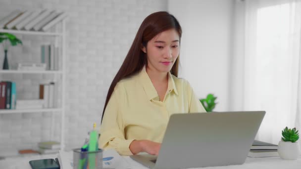 ラップトップコンピュータの前に座っている美しいアジアの女性は注文をする顧客からの呼び出しを持っています — ストック動画