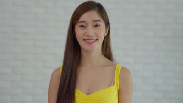 黄色の服を着た美しい笑顔アジアの女性は コロナウイルスの拡散を防ぐためにマスクを着用しています 親指を立てて陽気な顔をしてた 個人用保護具Covid — ストック動画