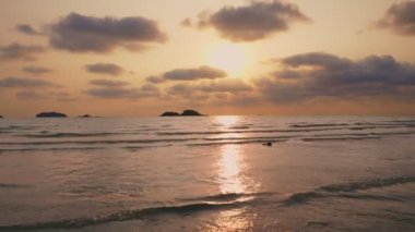 Dramatik deniz gündoğumu. Yanan gökyüzü ve parlayan altın dalgalar. Denizde romantik, renkli güneş ışığı. Güneşin su yüzeyindeki yansıması..