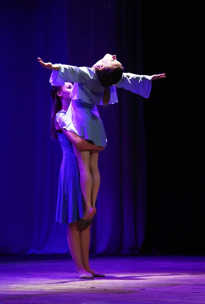 Två flickor dansar modern dans. Man stöder den andra i fo — Stockfoto