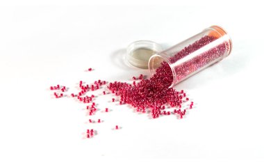 Beyaz bir backgrou üzerinde bir kavanoz gelen kırık mercan şeffaf boncuk