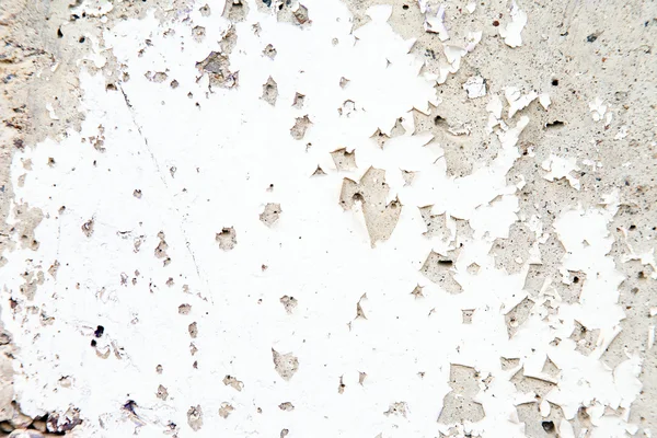Old peeling white paint on a concrete wall with cracks. — Stock Photo, Image